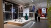 Blick in einen Ausstellungsraum mit vielen Kleidungsstücken.