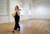 Eine Frau geht mit einem Instrument durch einen leeren Raum.