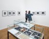 Ein Ausstellungsraum mit gerahmten Schwarz-Weiss-Fotografien an den Wänden.